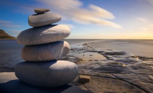 a cairn off smooth, flat stones with the ocean in the background